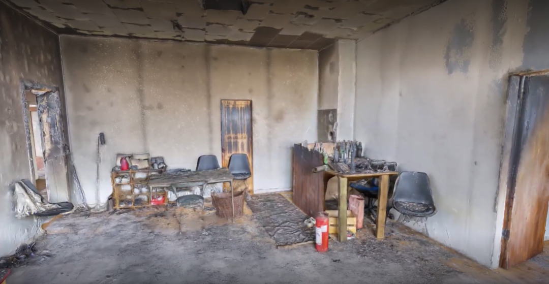 Still image taken from the digital virtual reality scene that shows a burned room